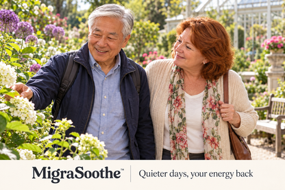An older Chinese man and his auburn-haired English wife exploring a flowering garden together.